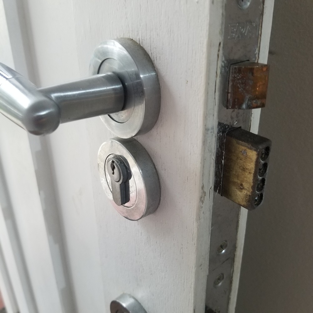 old white wooden door with two euro locks 003